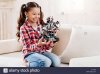 delighted-girl-playing-with-robot-JJ71TM.jpg