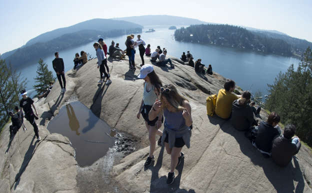 Hikers fail to practice social distancing as they gather at the top of popular hiking trail, Quarry Rock in Deep Cove in North Vancouver Friday, March 20, 2020. Health officials are asking Canadians to social distance themselves as to help contain the spread of COVID-19.