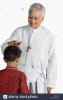 priest-blessing-a-boy-and-smiling-B5WK7D.jpg