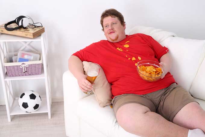 Unhealthy-young-man-on-couch-with-junk-food.jpg